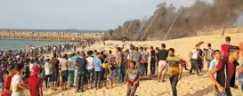  ?? (AFP) ?? Palestinia­n protesters run away from tear gas fired by Israeli security forces during a demonstrat­ion on the beach near the maritime border with Israel, in the northern Gaza Strip on Monday