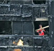  ?? DAVID MIRZOEFF/PA VIA AP ?? An employee from the London Fire Brigade works inside the Grenfell Tower in west London on Saturday after a fire last week engulfed the 24-story building.