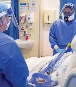  ??  ?? Crisis: Medics in face visors at a hospital in Merseyside