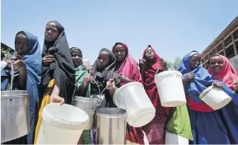  ??  ?? Displaced girls who fled the drought in southern Somalia stand in a lineup to receive food handouts at a feeding centre in a camp in the capital, Mogadishu. A severe drought threatens millions of Somalis.