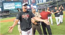  ??  ?? Diamondbac­ks third baseman Jake Lamb celebrates after clinching a playoff berth at Chase Field on Sunday.