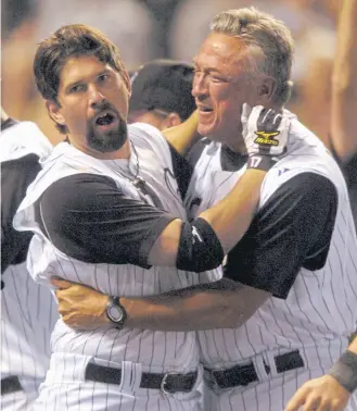  ??  ?? Todd Helton, left, and Rockies manager Clint Hurdle celebrate Helton’s walk-off homer to beat the Dodgers on Sept. 18, 2007. That play is credited for igniting Rocktober.