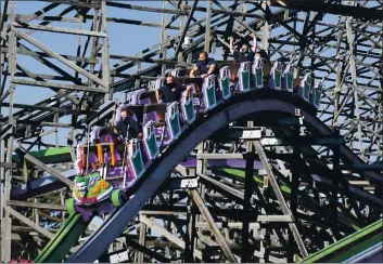  ?? PHOTOS BY CHRIS RILEY — TIMES-HERALD ?? Vallejo firefighte­rs, from left, Stephen Kay, Brett Bullock, Brad Anderson and Kevin Reustle ride The Joker on the first day that Six Flags Discovery Kingdom re-opened thrill rides after the COVID-19 pandemic shut down. Six Flags was the first theme park in California to re-open its rides and asked first responders to be the first to ride.