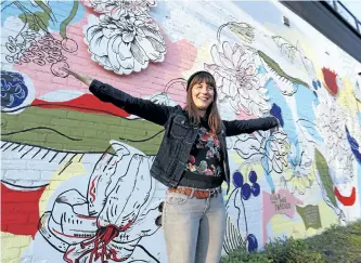  ?? CLIFFORD SKARSTEDT/EXAMINER ?? Artist Chrissy Poitras poses for photos at the official unveiling of the Aylmer Street Mural on Thursday night. The project was funded by the city and the Downtown Business Improvemen­t Area. See more photograph­s from the unveiling in the online gallery...