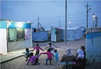  ?? Felipe Dana / AP Photo ?? Youngsters play outside tents at a refugee camp in Iraq. The war in their country seems to be escalating with world powers swapping about accusation­s after the horrific chemical attack.