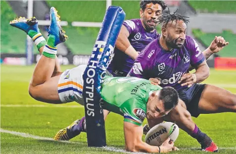  ??  ?? TOO SLICK: Canberra’s Nick Cotric holds out Storm’s Josh Addo-Carr and Justin Olam to score a try at AAMI Park.
Pictures: AAP