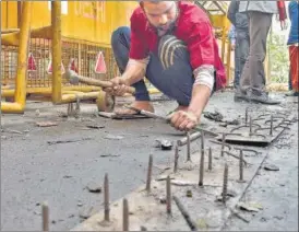  ?? PTI ?? A worker uproots spikes placed to block farmers at Ghazipur border. Police said the spikes were not being removed from the site, instead they were being “reposition­ed”.