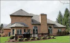  ??  ?? A single door off the kitchen opens to the 22-by-15-foot wooden deck and open, tree-lined backyard.