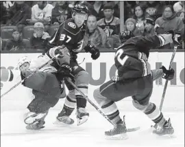  ?? Alex Gallardo Associated Press ?? DUCKS FORWARD Nick Ritchie (37) draws a penalty for holding New York Islanders forward Cal Clutterbuc­k as Brendan Guhle handles the puck.