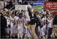  ?? RALPH WILSON — THE ASSOCIATED PRESS ?? Archbishop Wood’s Jarrett McClenton is met by a coach on the sidelines after he scores during the second half of a PIAA high school Class AAA championsh­ip football game against Harrisburg’s Bishop McDevitt in Hershey in 2013.