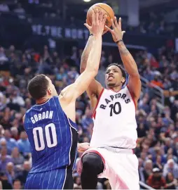  ?? (Reuters) ?? TORONTO RAPTORS guard DeMar DeRozan gets a shot off over Orlando Magic defender Aaron Gordon for two of his game-high 36 points in the Raptors’ 131-112 home victory on Monday night.