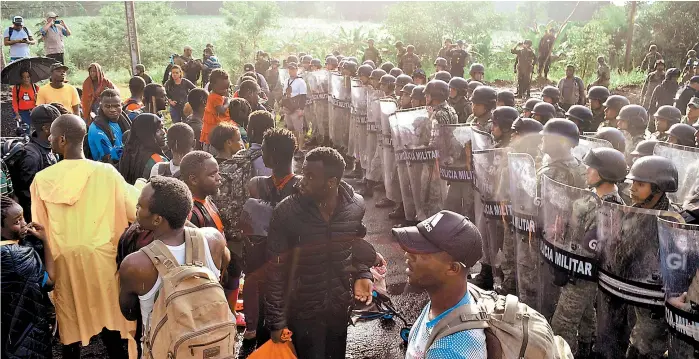  ?? REUTERS ?? Los migrantes estuvieron 20 minutos frente al cerco policiaco para pedir libre paso, aunque finalmente se replegaron.