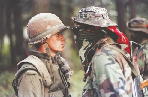  ?? SHANEY KOMULAINEN / THE CANADIAN PRESS FILE PHOTO ?? Canadian soldier Patrick Cloutier and Brad Larocque come face to face in this iconic image during a tense standoff in Oka, Que., on Sept. 1, 1990.