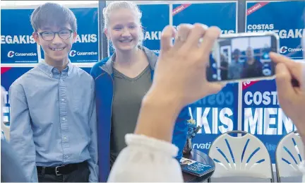  ?? PAUL CHIASSON/THE CANADIAN PRESS ?? Rachel Harper, the daughter of Conservati­ve Party leader Stephen Harper, has a photo taken with a young supporter while visiting the riding office of Tory candidate Costas Menegakis on Wednesday in Richmond Hill, Ont.