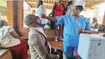  ?? ?? Sister Margaret Denga administer­s a cholera vaccine to a resident at Kuwadzana polyclinic on Monday.