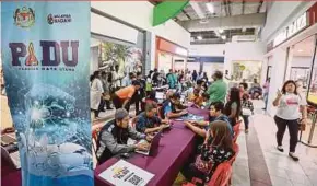  ?? PIC BY ASYRAF HAMZAH ?? People registerin­g with the Central Database Hub (Padu) at Giant Batu Caves near Kuala Lumpur yesterday.