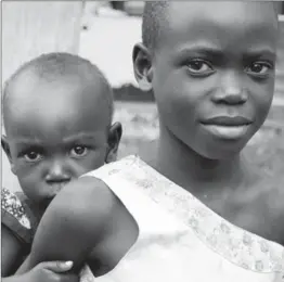  ?? PHOTO COURTESY OF SAVE THE MOTHERS ?? A girl and her sibling in Uganda look hard into the camera. Early pregnancie­s of teenage girls, many who are out of school, is one cause of high maternal death rates across the developing world.