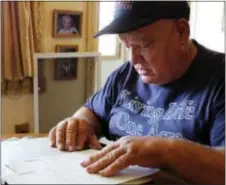  ?? MICHAEL RUBINKAM — THE ASSOCIATED PRESS ?? In this photo, Jan Brown looks over a royalty statement at his home in Wyalusing, Pa. Brown and other landowners with natural gas wells contend that gas companies are ripping them off by taking improper deductions from their royalty checks. The...