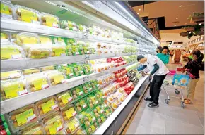  ?? HONG MENEA ?? Customers shop at a supermarke­t in the capital’s Meanchey district in December 2022.