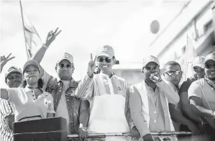  ?? — Gambar AFP ?? YAKIN MENANG: Rajoelina (tengah) menyapa penyokong sewaktu mengadakan perarakan kempen pada 16 Disember lepas di Antananari­vo, Madagascar.