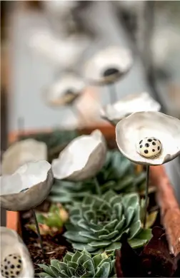  ??  ?? En attendant le retour du printemps, les fleurs en céramique façonnées par Patricia s’épanouisse­nt dehors, sans craindre le gel alsacien.