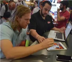  ?? THE TOPPS COMPANY/TRIBUNE NEWS SERVICE ?? New York Mets pitcher Noah Syndergaar­d and Chris R. Vaccaro, director of app production for The Topps Company, take part in a Topps’ MLB Bunt app promotion.