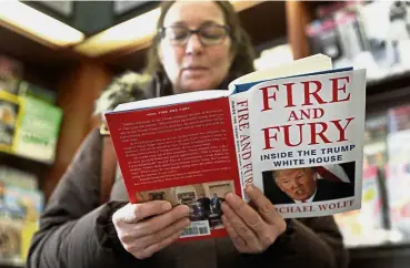  ?? — AP ?? Page turner: A reader flipping through a copy of the book ‘Fire and Fury: Inside the Trump White House’ at a bookstore in Chicago.