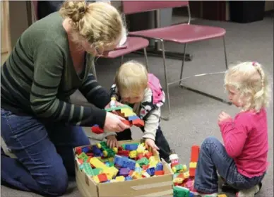  ?? CHARLES PRITCHARD — ONEIDA DAILY DISPATCH ?? Janielle King, left, works with her daughters Gabrielle, center, and Krisalynn to build a bridge for the Cazenovia Public Library’s LEGOMy Library event on Monday, Sept. 10, 2018.