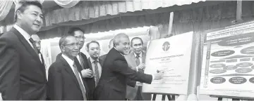  ??  ?? Awang Tengah signs the ‘STIDC Strategic Planning Plan, 2016-2020’ plaque while (from left) Sudarsono, Sarudu, Julahi, Abdul Aziz and Len look on. — Photo by Jeffrey Mostapa