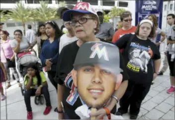  ?? THE ASSOCIATED PRESS ?? Zoraida Martinez holds a cardboard cutout of former Marlins pitcher Jose Fernandez at a makeshift memorial for Fernandez outside Marlins Park before Monday’s game between the Marlins and Mets in Miami.