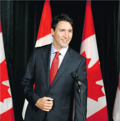  ?? TODD KOROL / THE CANADIAN PRESS ?? Prime Minister Justin Trudeau greets the press before going into the Liberal cabinet retreat in Calgary on Monday. The focal point of the two- day meeting is dealing with U. S. President Donald Trump.