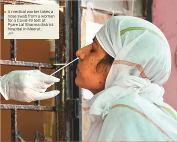  ?? AFP ?? A medical worker takes a nose swab from a woman for a Covid-19 test at Pyare Lal Sharma district hospital in Meerut.