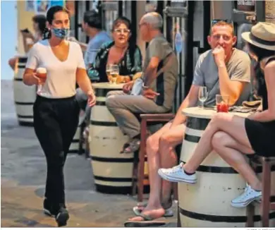  ?? JAVIER ALBIÑANA ?? Una mujer atiende a la clientela de un bar este verano.