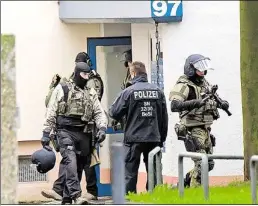  ?? AP-BILD: MEYER ?? Polizisten verlassen nach dem Anti-Terror-Einsatz in Chemnitz einen Plattenbau.