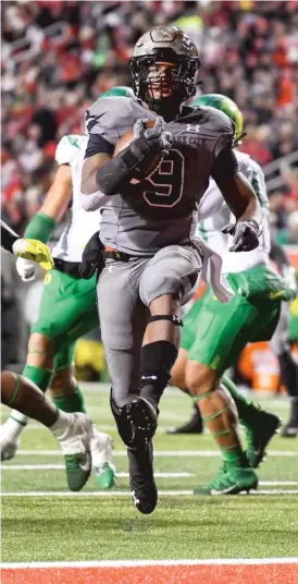  ?? AP ?? Running back Tavion Thomas races into the end zone during the second half of Utah’s one-sided victory over No. 3 Oregon that threw a monkey wrench into the CFP rankings.