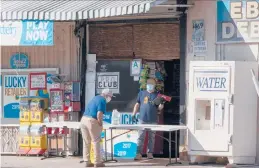  ?? DAMIAN DOVARGANES/AP 2020 ?? A customer purchases water in Los Angeles. An influx of federal funds from the latest virus relief bill may help some states improve drinking water.