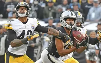  ?? Peter Diana/Post-Gazette photos ?? Somehow, Derek Carr completed this pass to Seth Roberts to set up the winning touchdown for the Raiders in Oakland after the Steelers had rallied.