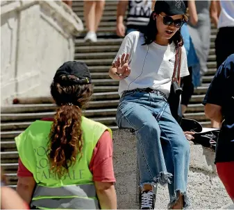  ?? AP ?? A police officer asks a woman not to sit on the Spanish Steps, in Rome.