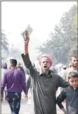  ??  ?? A supporter of Egyptian President Mohamed Morsi holds a Quran and shouts slogans at a rally in front of Cairo University in Cairo, Egypt, Dec 1. Tens of thousands of people waving Egyptian flags and hoisting large pictures of the president were...