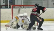  ?? GENE WALSH — DIGITAL FIRST MEDIA ?? Hatboro-Horsham’s Aidan Esack goes to free the puck from Wissahicko­n’s goalie Michael Henderson during their game Wednesday.