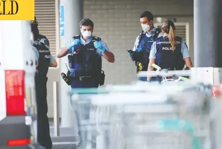  ?? FIONA GOODALL / GETTY IMAGES ?? Officers stand guard in front of an Auckland, N.z.-area mall on Friday where an ISIL supporter stabbed six people before being shot dead by police.