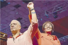  ??  ?? Peter Phillips and Portia Simpson Miller join hands after passing the presidency baton of the People’s National Party.