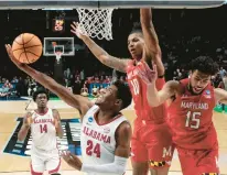  ?? BUTCH DILL/AP ?? Alabama forward Brandon Miller (24) goes up for a reverse layup around Maryland forward Julian Reese (10) and forward Patrick Emilien (15) in the first half Saturday night in Birmingham, Alabama.