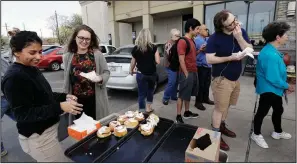  ?? AP/ERIC GAY ?? Lety Vargas (left) offers cinnamon rolls to voters as they wait in line at an Austin, Texas, grocery store that served as a polling site for Tuesday’s primary elections.