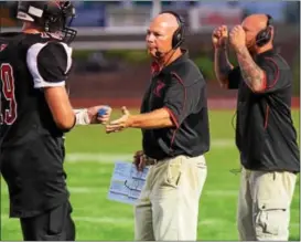  ?? AUSTIN HERTZOG - DIGITAL FIRST MEDIA ?? George Parkinson, center, announced his resignatio­n as Boyertown head coach following Saturday’s win over Pottstown.