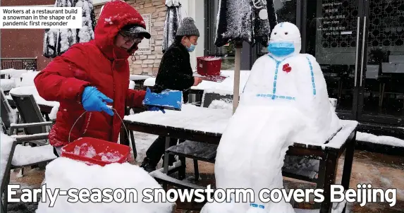  ?? ?? Workers at a restaurant build a snowman in the shape of a pandemic first responder