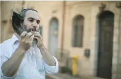  ?? ( Hadas Parush/ ?? A MAN blows a shofar in Jerusalem’s Nahlaot neighborho­od. Flash90)