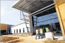  ?? STAN CARROLL/THE COMMERCIAL APPEAL ?? Workers move sections of glass to be installed at the entrance to the DCS Career Technology Center-West building in Horn Lake last week. Classes will meet in the building Wednesday.