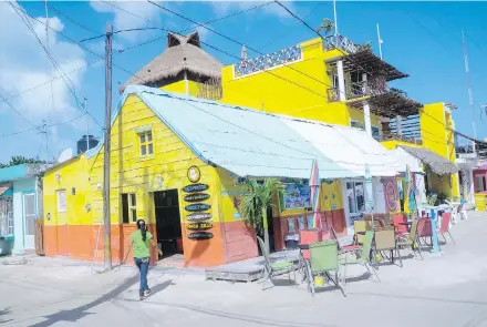  ?? PHOTOS BY CHRISTOPHE­R REYNOLDS, LOS ANGELES TIMES ?? Even the busiest streets in tiny Isla Holbox, Mexico, are unpaved and dominated by pedestrian­s, bikes, golf carts and dogs.