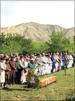  ?? ANDREW QUILTY/AFP ?? Prayers are said before the burial of Agence France Presse Afghanista­n chief photograph­er Shah Marai Faizi in Gul
Dara, Kabul, on Monday after his death in a suicide bombing claimed by Islamic State.